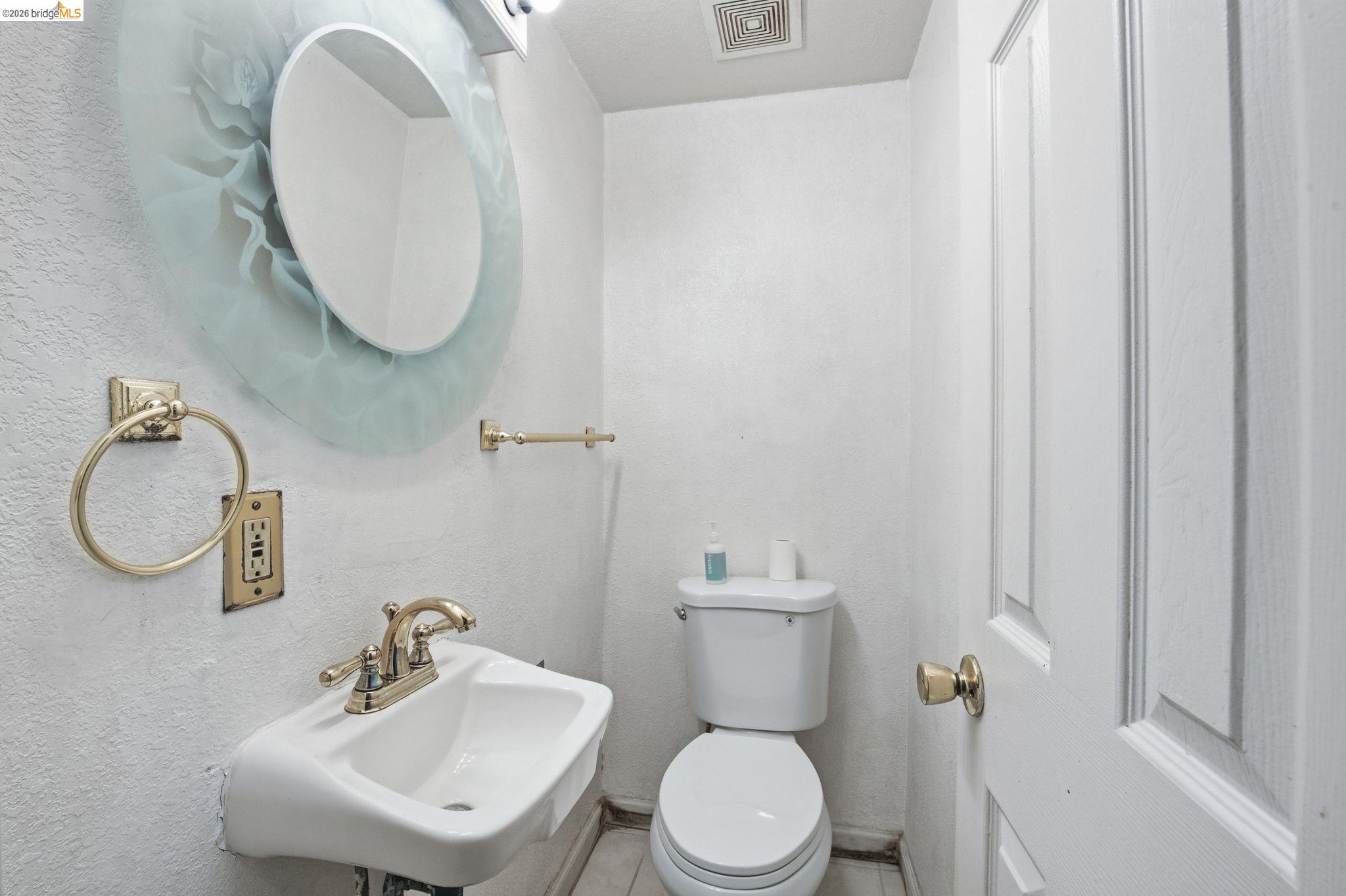 1496 Adeline Street Oakland, CA 94607 - Photo 9 of 17 a bathroom with a toilet a sink and mirror
