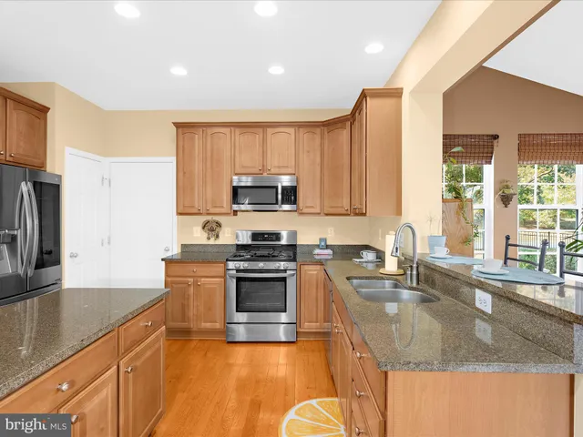 a kitchen with granite countertop wooden cabinets and a stove top oven