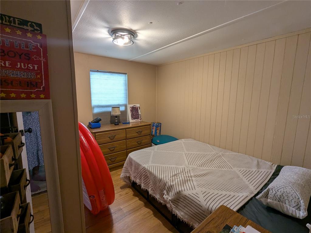 53 Sunset Circle Lake Alfred, FL 33850 - Photo 9 of 13 a bedroom with a bed and a chandelier