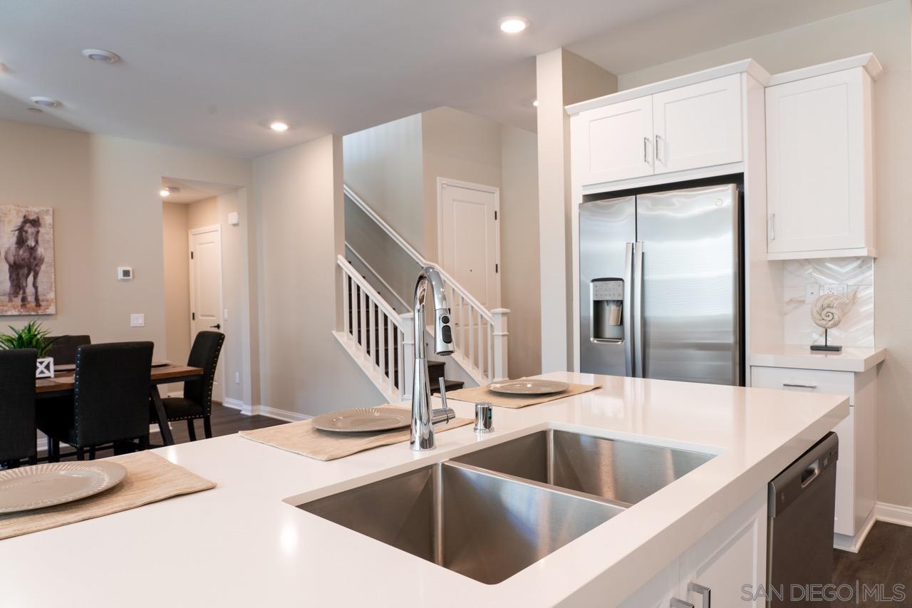 a kitchen with a refrigerator sink and chairs