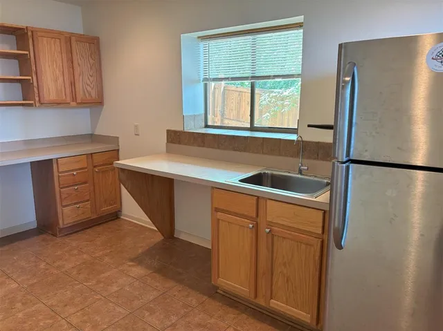 a small white house with a large pool table and chairs