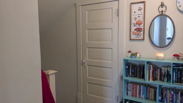 a view of a hallway with wooden floor and closet