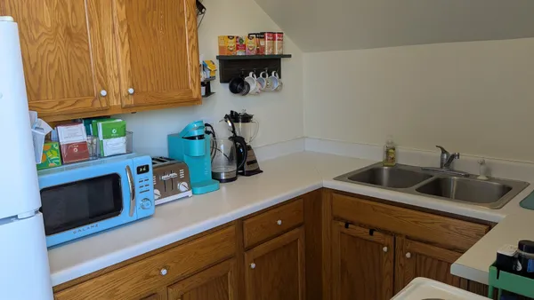 a kitchen with stainless steel appliances a sink dishwasher and cabinets with wooden floor