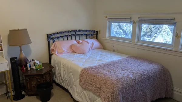 a bed sitting in a bedroom next to a window