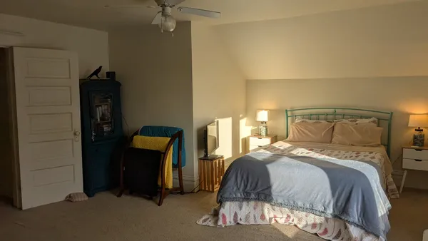 a bedroom with a bed and a chandelier