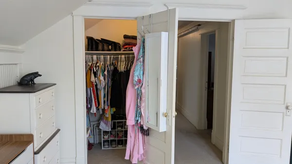 a view of walk in closet with clothes and shoes