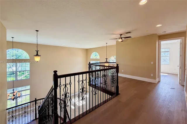 a view of hallway with wooden floor and windows
