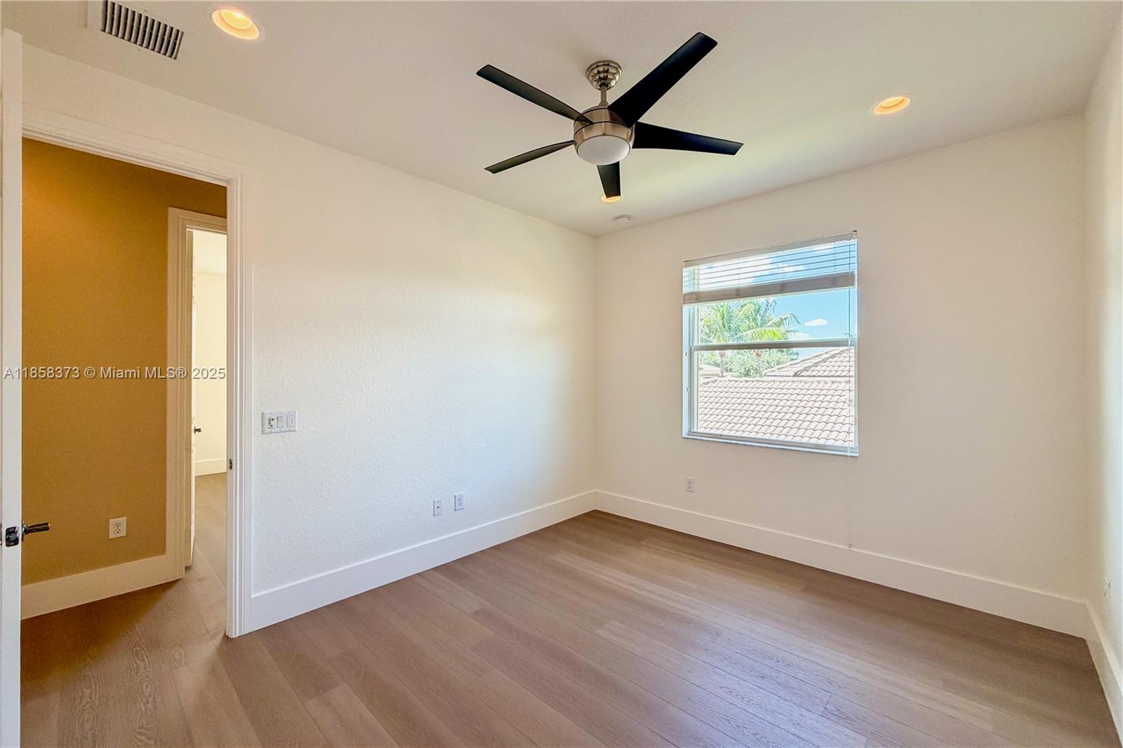 11894 Fox Hill Circle Boynton Beach, FL 33473 - Photo 25 of 35 an empty room with wooden floor and windows
