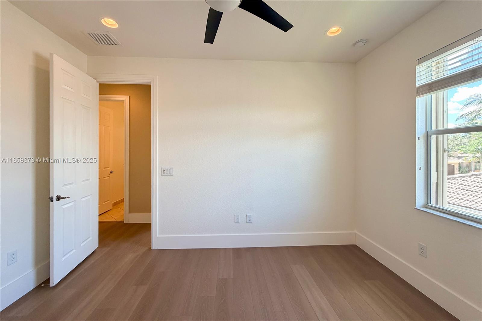 11894 Fox Hill Circle Boynton Beach, FL 33473 - Photo 27 of 35 an empty room with wooden floor and window