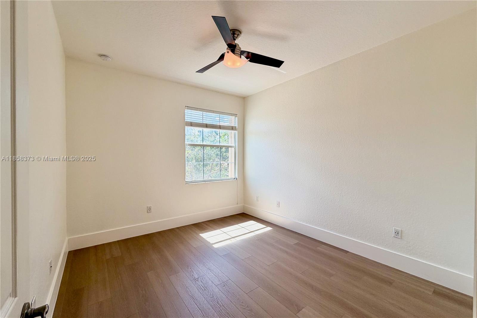 11894 Fox Hill Circle Boynton Beach, FL 33473 - Photo 28 of 35 an empty room with wooden floor fan and windows