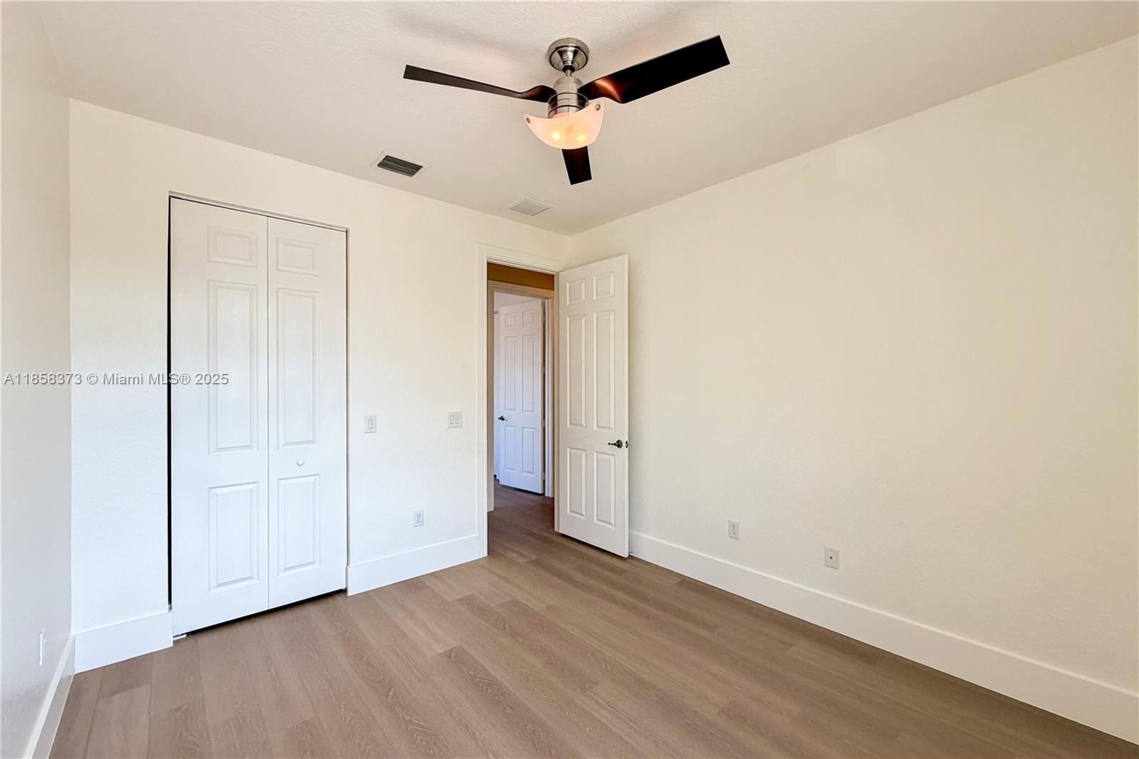 11894 Fox Hill Circle Boynton Beach, FL 33473 - Photo 29 of 35 an empty room with a ceiling fan and wooden floor