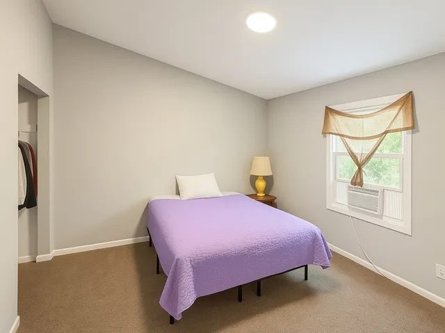 a bedroom with a bed and a window