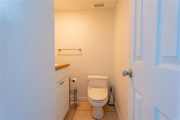 a view of a hallway with wooden floor and a bathroom view