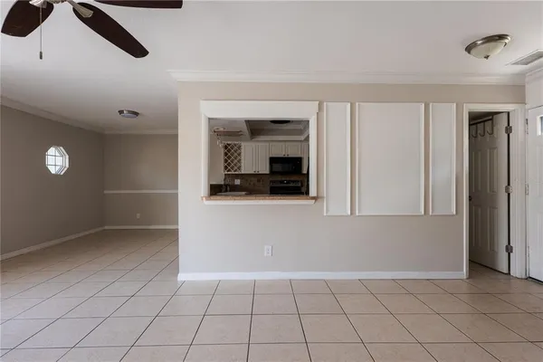 a view of an empty room with cabinet and windows