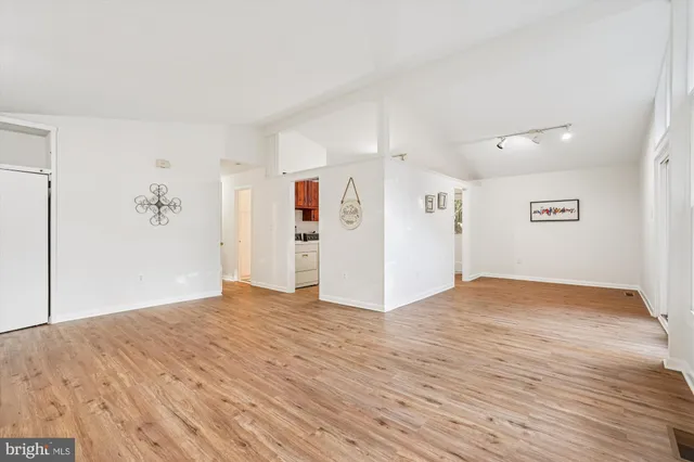 a view of empty room with wooden floor