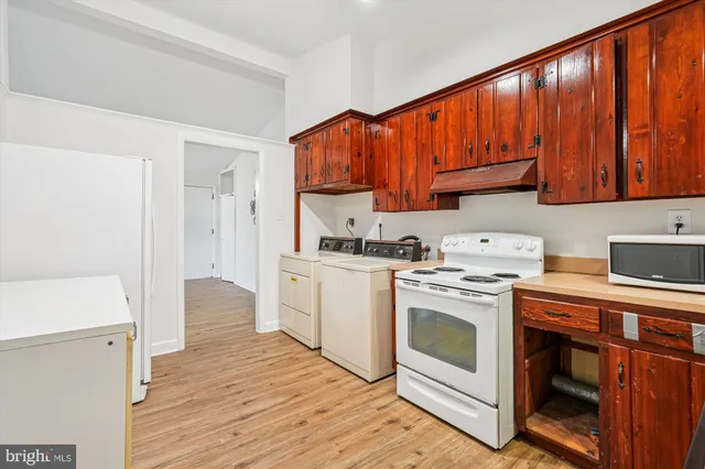 a kitchen with a white stove top oven and cabinets