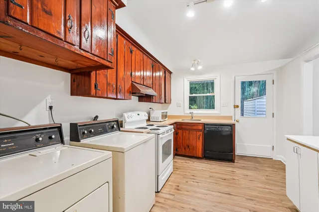 a kitchen with a stove sink and cabinets