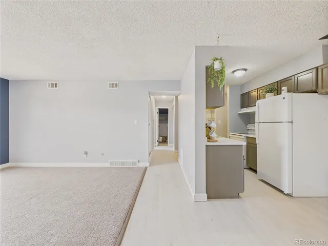 a view of kitchen with furniture and refrigerator