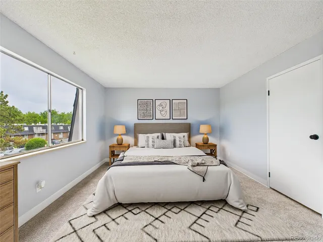 a large bed sitting in a bedroom next to a window