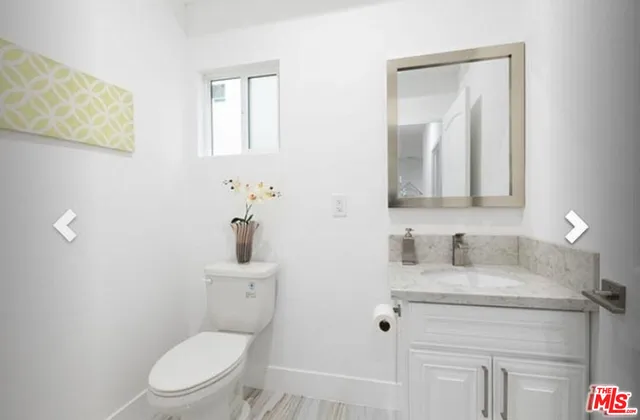 a bathroom with a toilet a sink a mirror and vanity