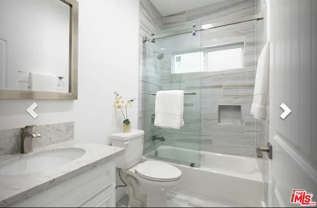 a bathroom with a granite countertop sink a toilet and shower