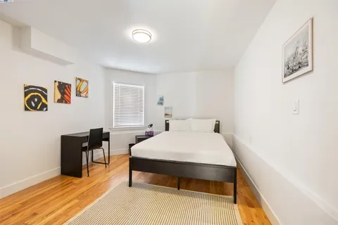 a bed sitting in a bedroom next to a window with chair