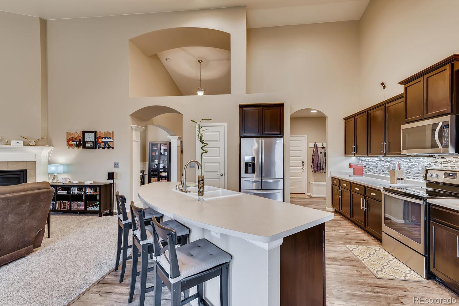 8413 Raspberry Drive Frederick, CO 80504 - Photo 9 of 27 a kitchen with stainless steel appliances granite countertop a stove a sink dishwasher and white cabinets with wooden floor