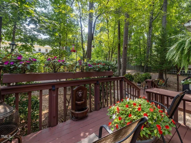 a view of a patio with table and chairs potted plants and large tree