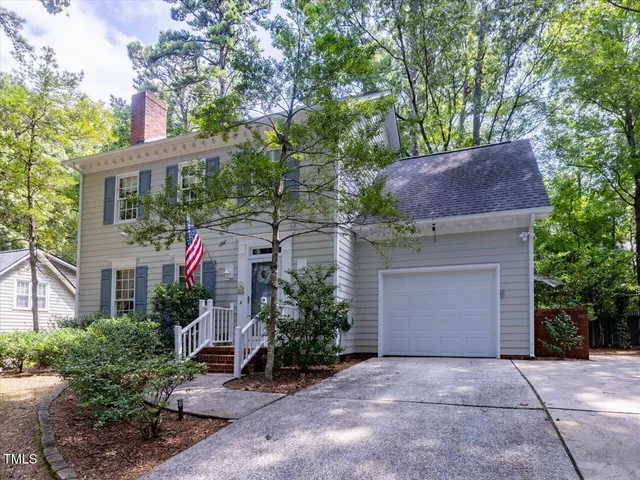 a front view of house with yard and trees around