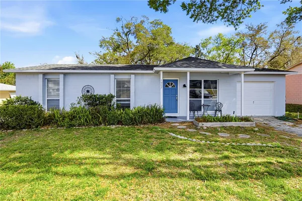 a front view of a house with a yard garage and outdoor seating