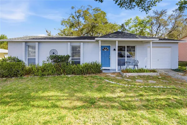 a view of a house with a yard and potted plants