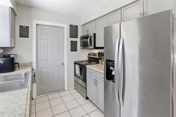 a kitchen with a refrigerator and a stove top oven