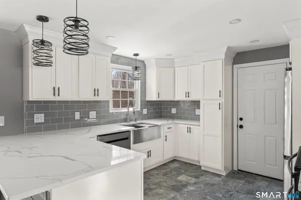 a kitchen with stainless steel appliances a sink stove and cabinets