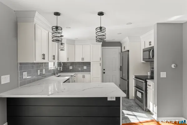 a kitchen with stainless steel appliances a stove and a sink