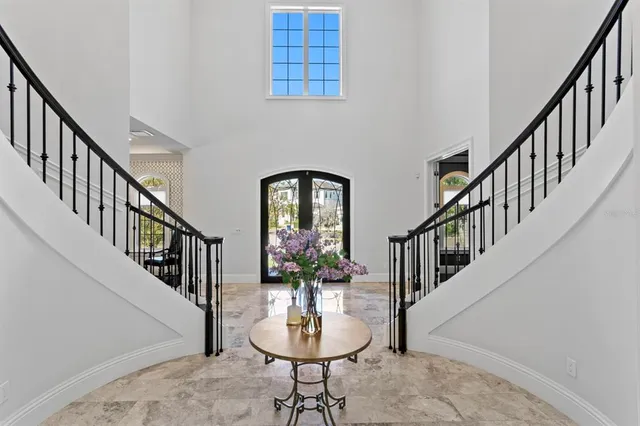 a view of staircase with railing and pendant lights