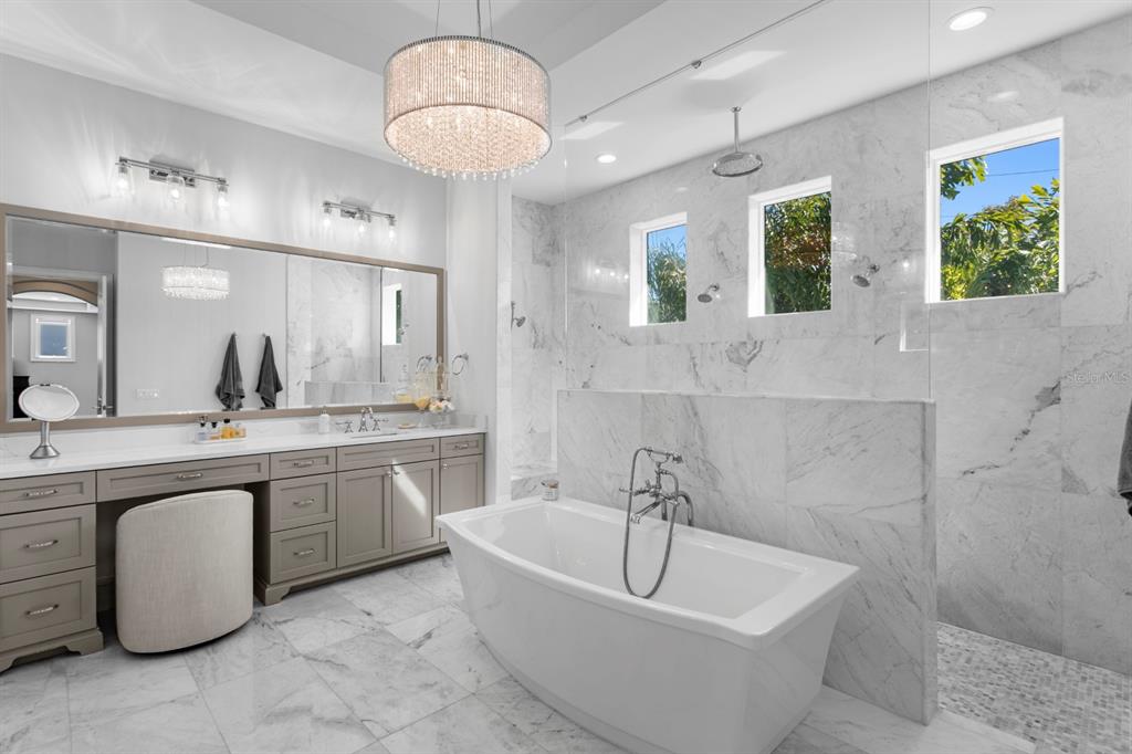2604 South Bryant Circle Tampa, FL 33629 - Photo 27 of 49 a bathroom with a tub a sink and a chandelier