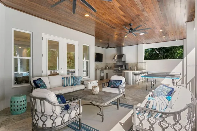 a living room with patio furniture and a floor to ceiling window