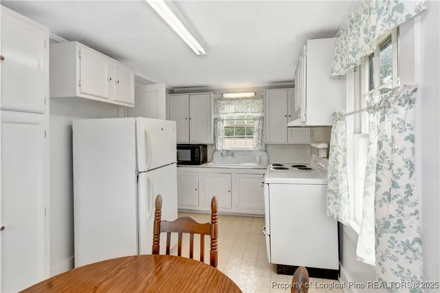 a kitchen with stainless steel appliances a refrigerator sink and white cabinets