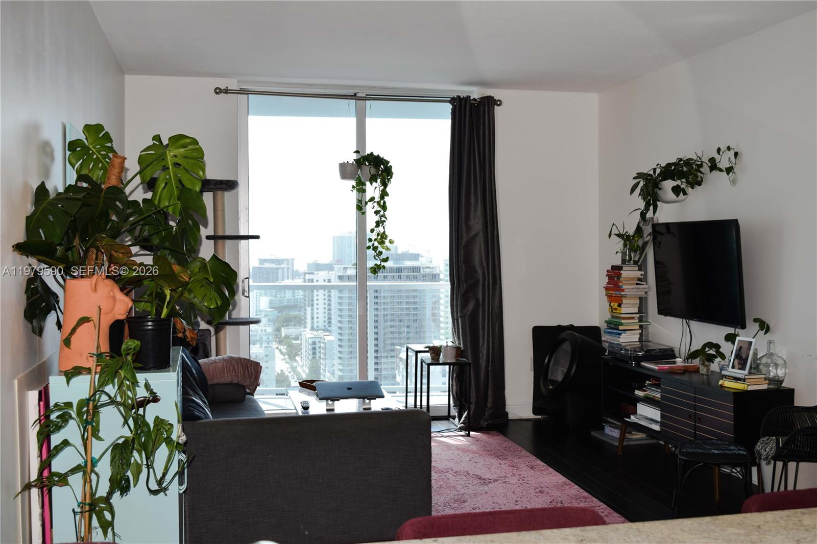 185 Southwest 7th Street, Unit 2814 Miami, FL 33130 - Photo 5 of 8 a living room with furniture potted plant and a large window