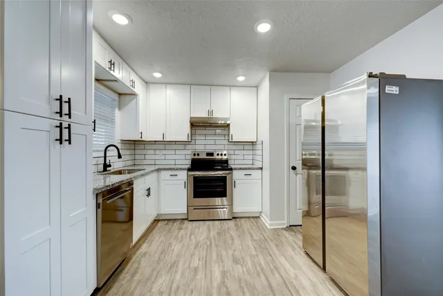 a kitchen with a refrigerator and a sink