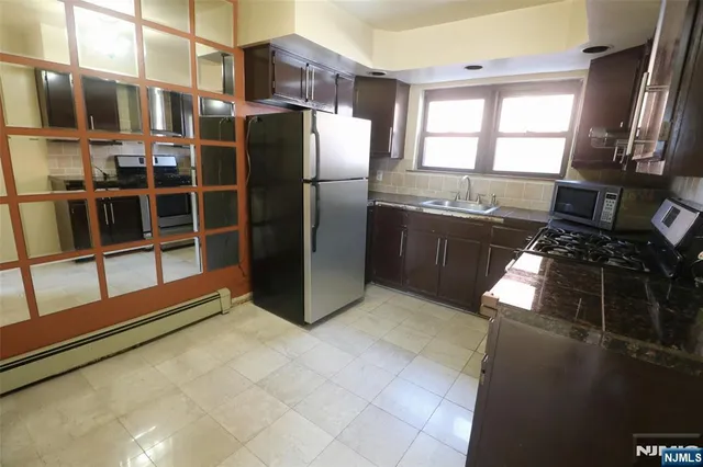 a kitchen with granite countertop a refrigerator stove and sink