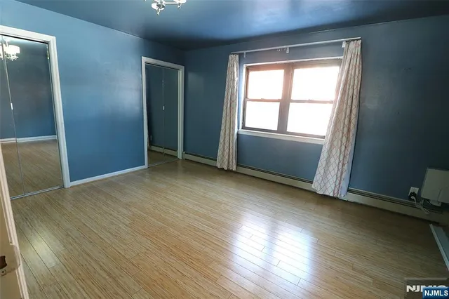 an empty room with wooden floor and a bathroom