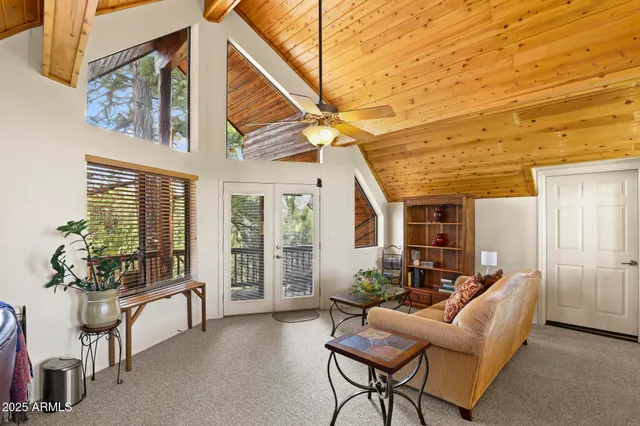 a living room with furniture a flat screen tv and a large window