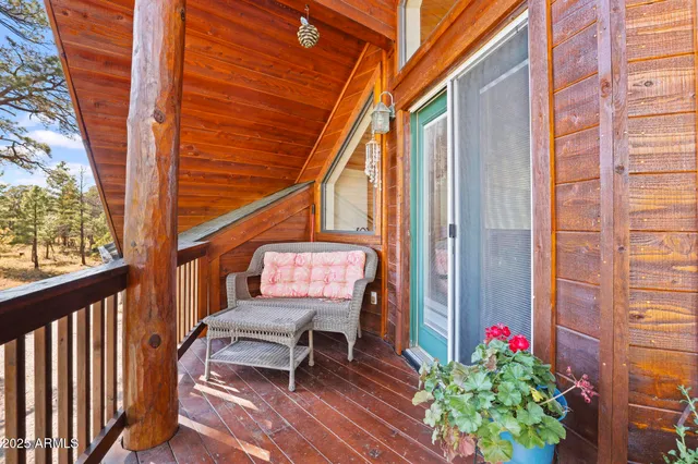a balcony with wooden floor and outdoor seating