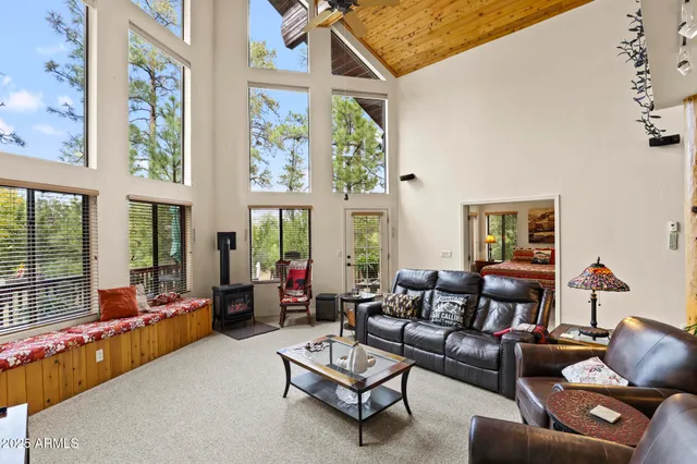 a living room with furniture and floor to ceiling windows