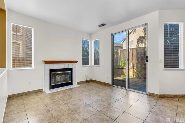 a view of an empty room with window and fire place