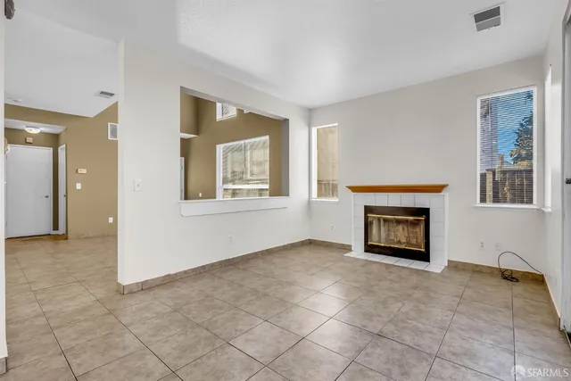 a view of an empty room with window and fire place