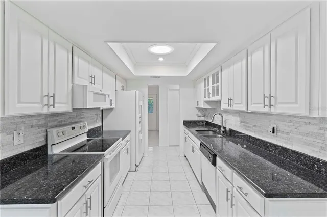 a kitchen with granite countertop a sink stove and cabinets