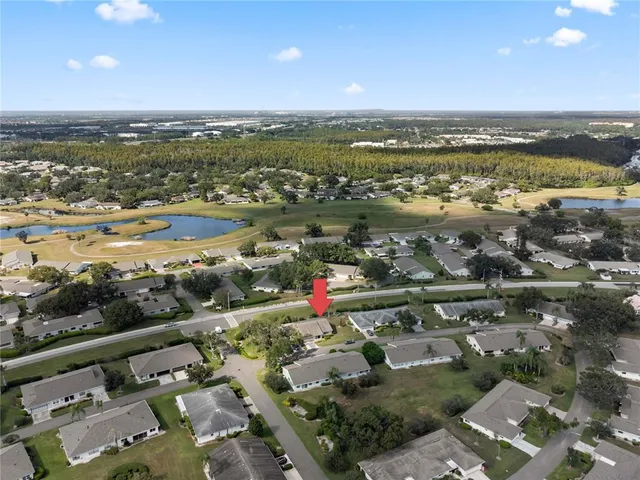 an aerial view of ocean and residential houses with outdoor space