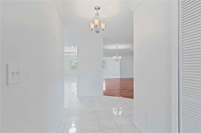 a view of a hallway with chandelier and entryway